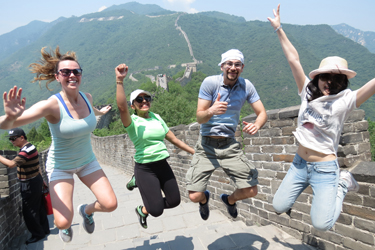 Students jumping in the air on top of the Great Wall of China